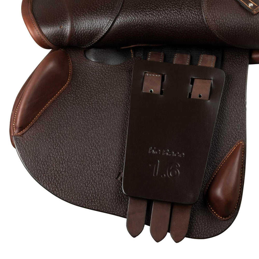 Close-up of a brown leather saddle with a brand label on a white background