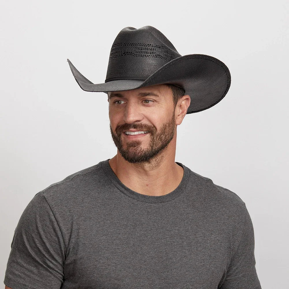 Man wearing a black cowboy hat against a plain background